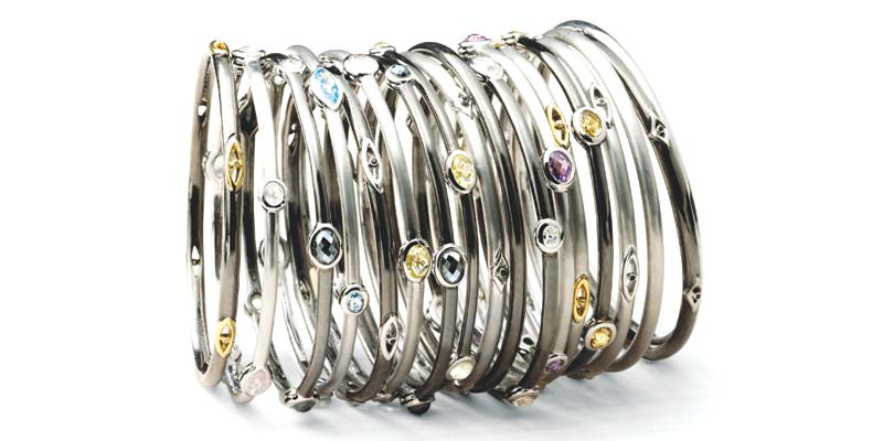 Assorted silver 'Cocktail Stax' bangles by Hera Jewellery, with midnight finish and gemstones.
