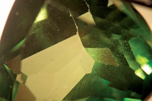 Photo courtesy Mark T. Cartwright Sold as a tsavorite garnet, this topaz has a vapour coating that becomes apparent with a white diffuser and proper orientation under the microscope.