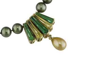 Photo courtesy Llyn L. Strelau 'Tierra' pendant clasp in 18-karat green gold set with green tourmaline, golden beryl, and accented with a yellow diamond and golden green South Sea pearl drop.