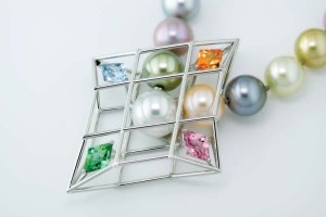 Photo courtesy Llyn L. Strelau The finished pendant in platinum, with pink and green tourmaline, aquamarine, spessartite garnet, and South Sea and freshwater pearls. The stones' cut is reflected in the pendant's design.