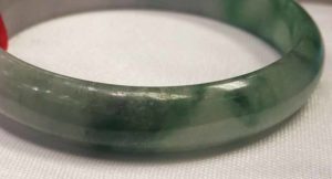 Bleaching lightens the colour of the black inclusions in flower green jade, but does not remove them entirely.