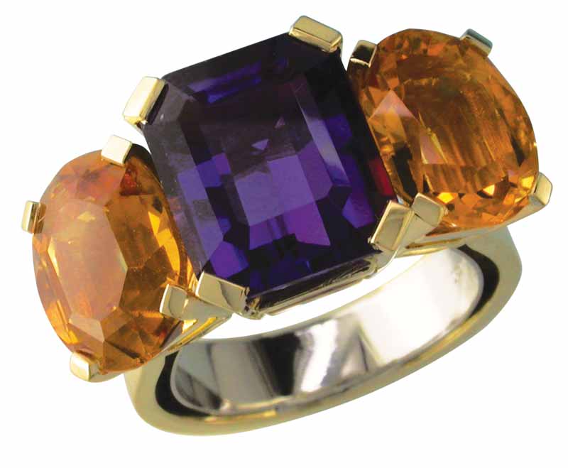 An 18-karat yellow gold ring with a white gold sizing spring inside, claw-set with large cushion-cut amethyst and two oval citrines.