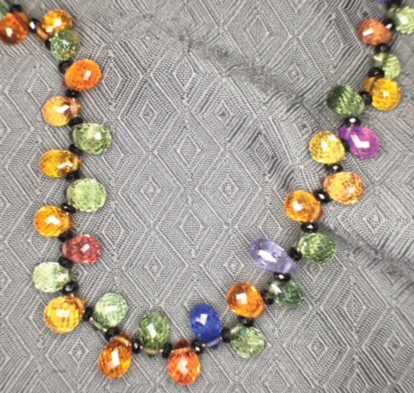 Faceted sapphires of different colours showcased on a beaded necklace.