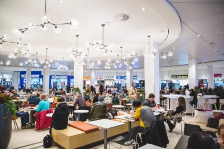 Interior of a busy mall food court.