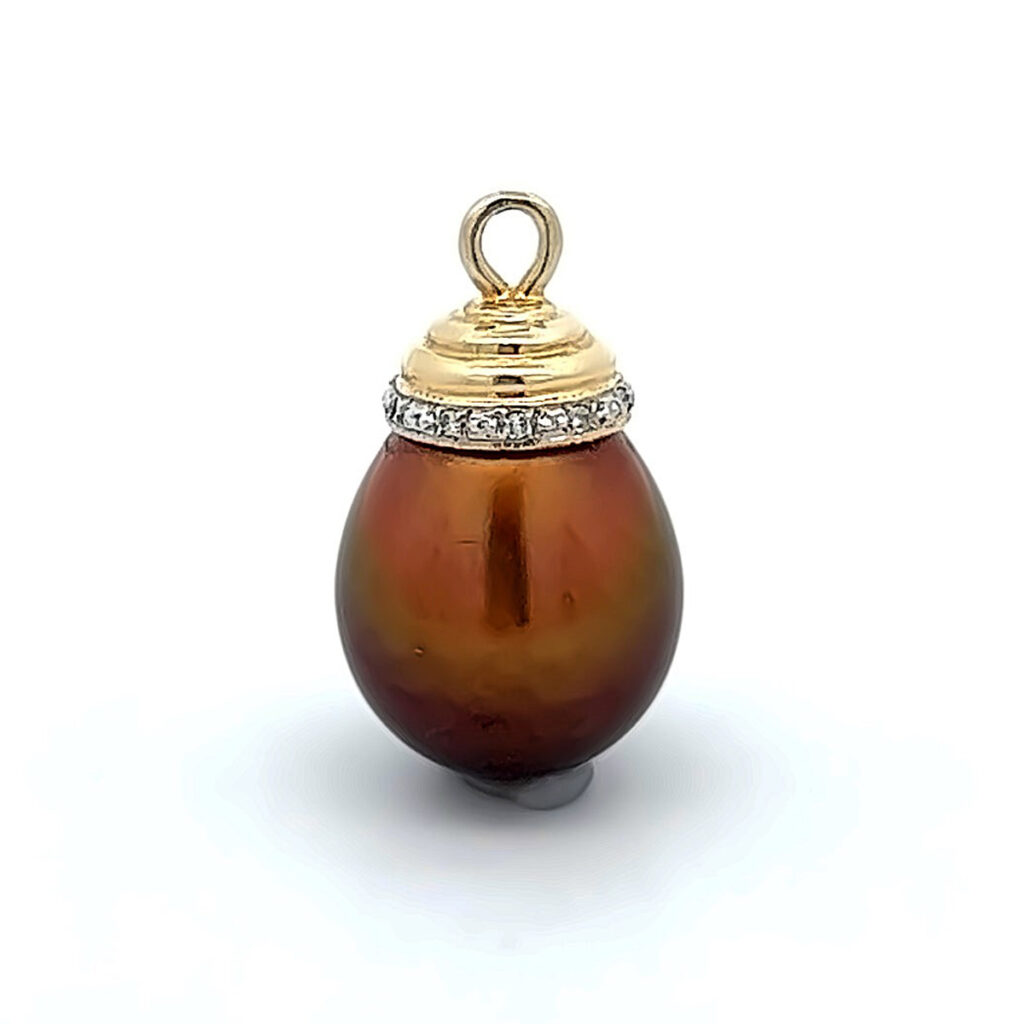 Close-up of a dark brown pearl pendant with gold and diamonds.