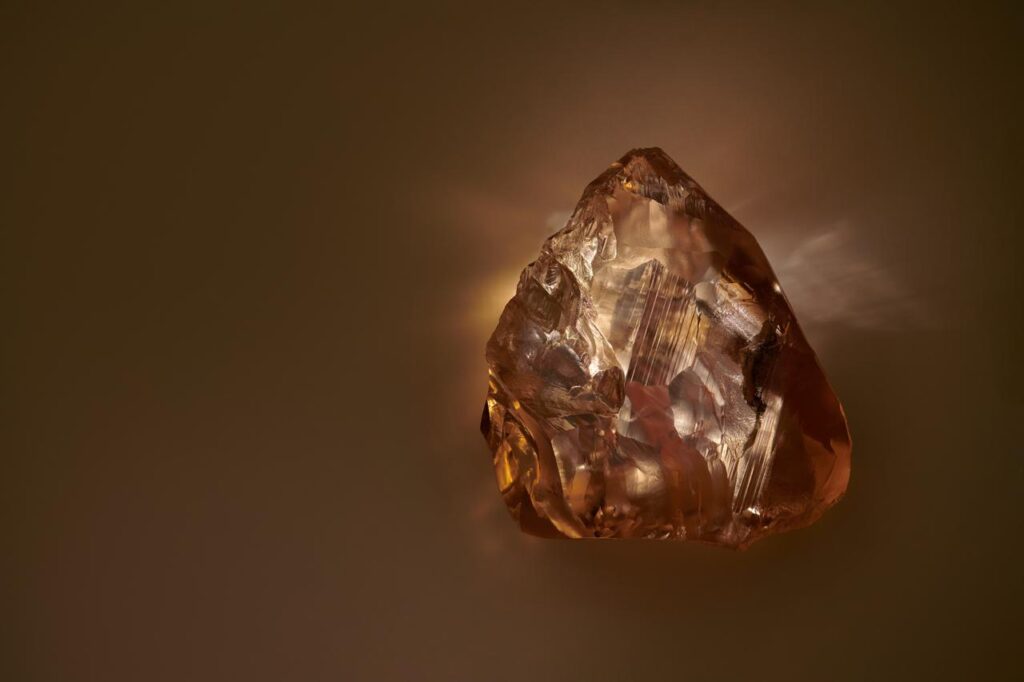 A rough-cut amber-hued diamond.