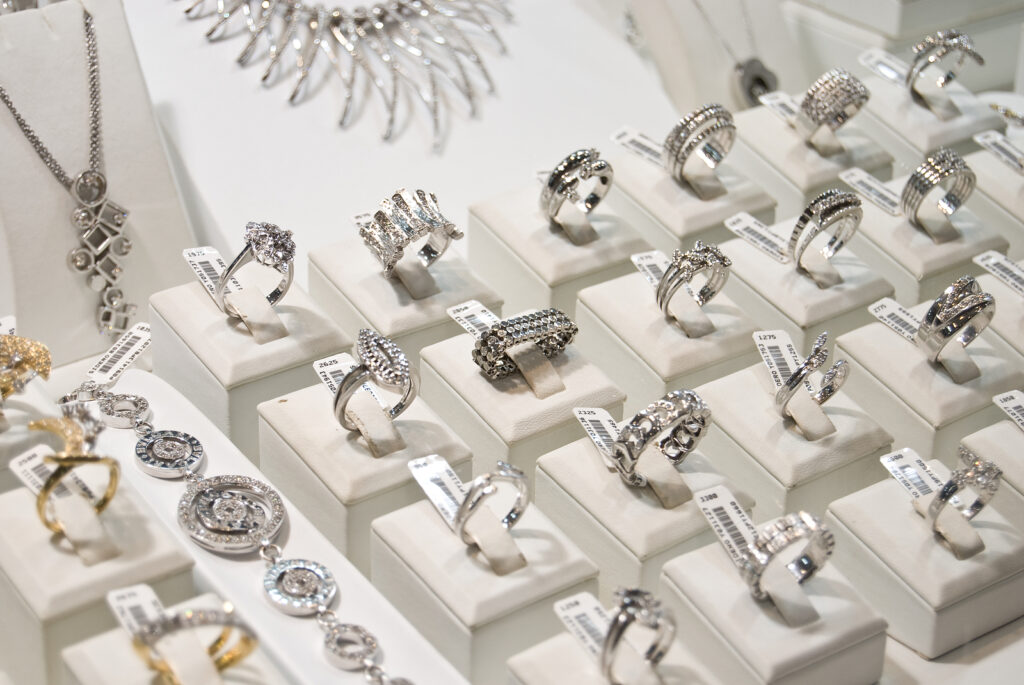A large assortment of diamond rings are in a jewellery store display case.