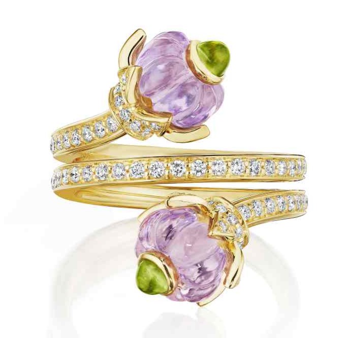 A gold diamond encrusted women's ring with two flowers at the top and bottom.