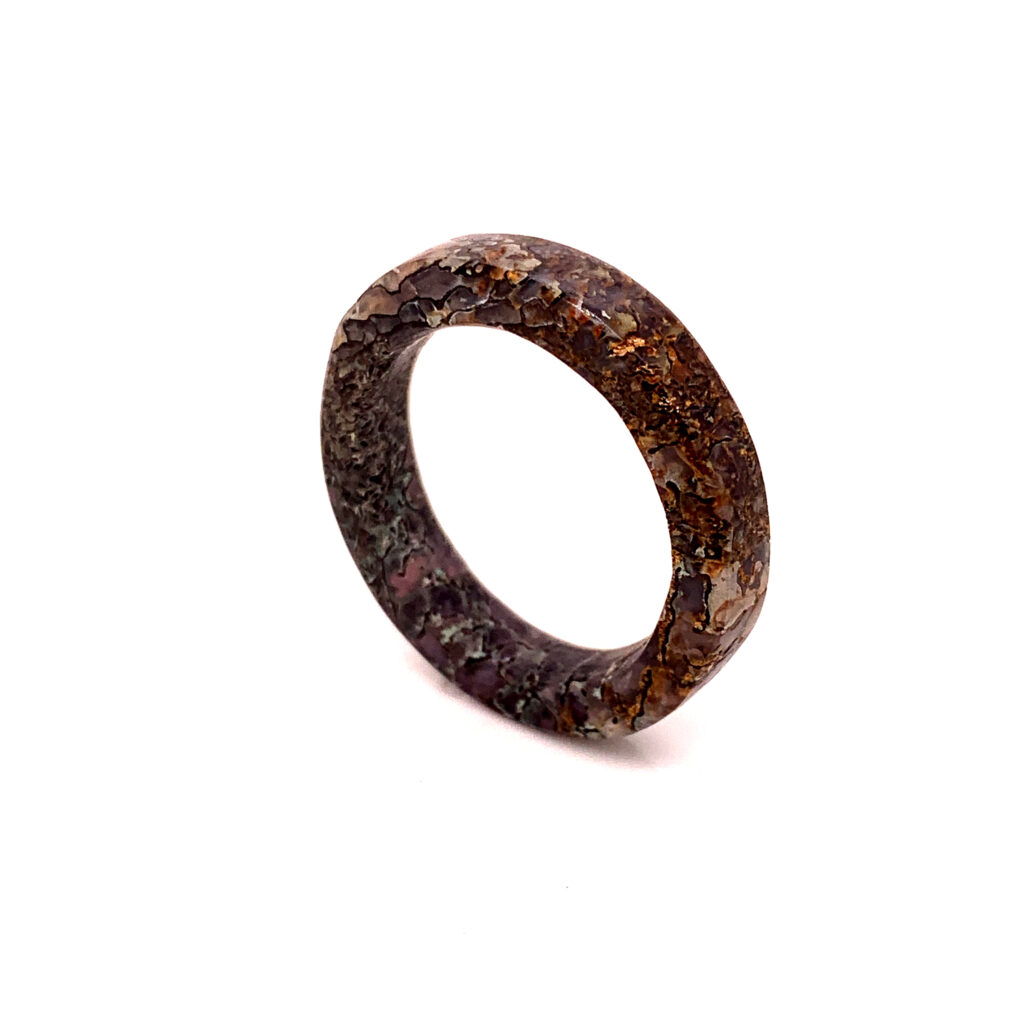 Close-up of a brown and speckled-coloured men's ring band on a white background.
