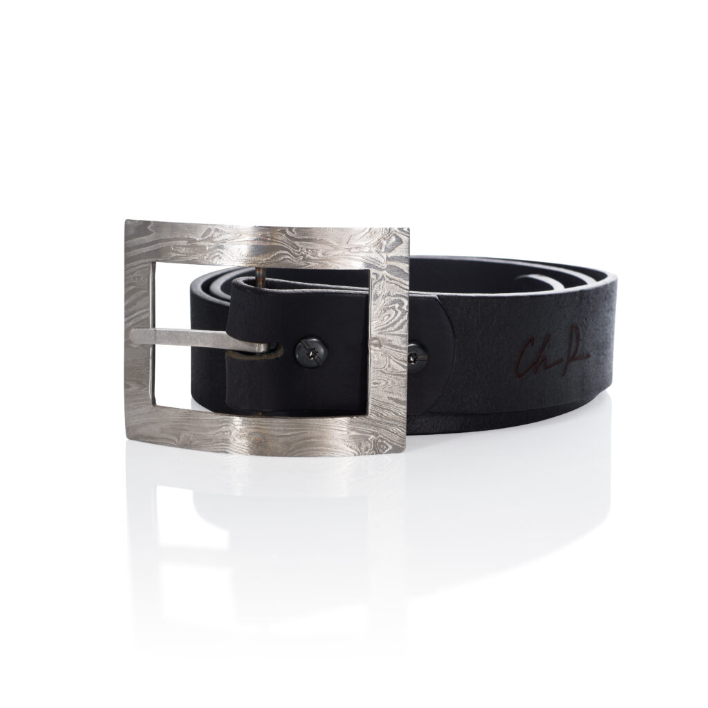 A silver belt buckle with black leather strap on a white background.