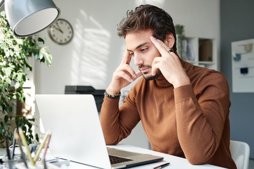 Man looks pensively at computer screen.