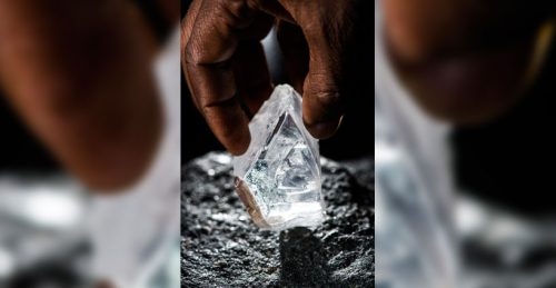 a hand holding a diamond