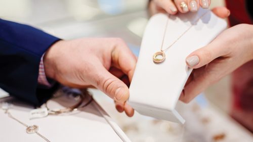 Hands holding a necklace for display.