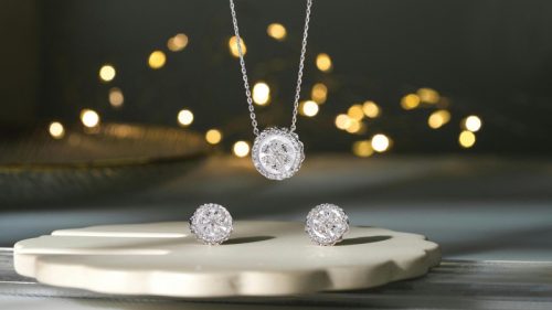 A suite of diamond earrings and necklace on display.