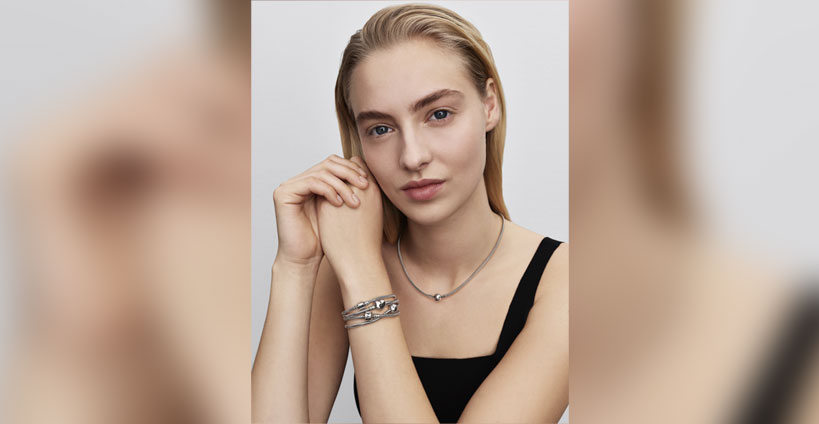 A model wears Pandora bracelets and a necklace.