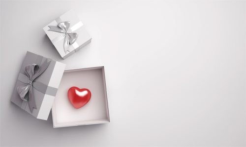 A silver gift box with a red heart inside.