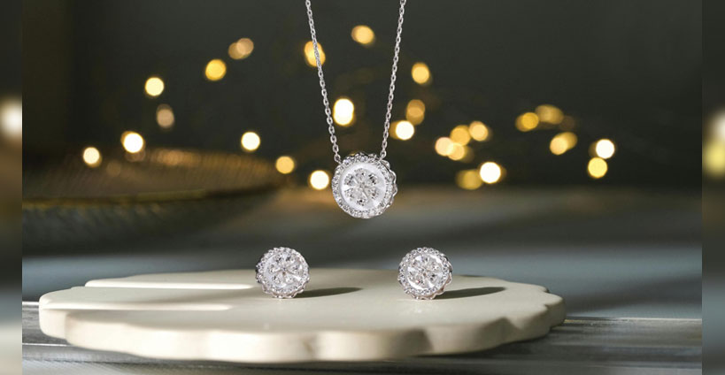 A suite of diamond earrings and necklace on display.