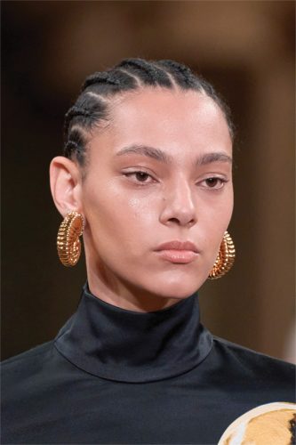 Model wearing gold earrings.