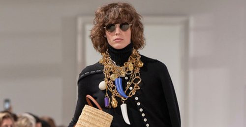 Model wears layered jewellery.