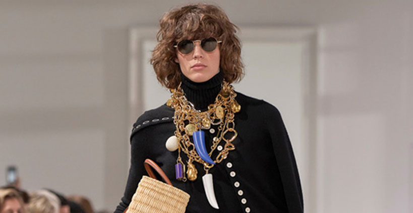 Model wears layered jewellery.