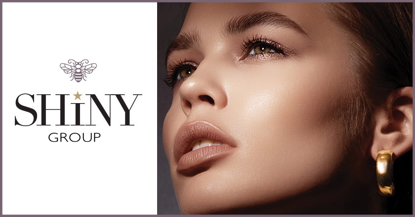 Close-up of a woman's face featuring a gold hoop earring next to the Shiny Group logo.
