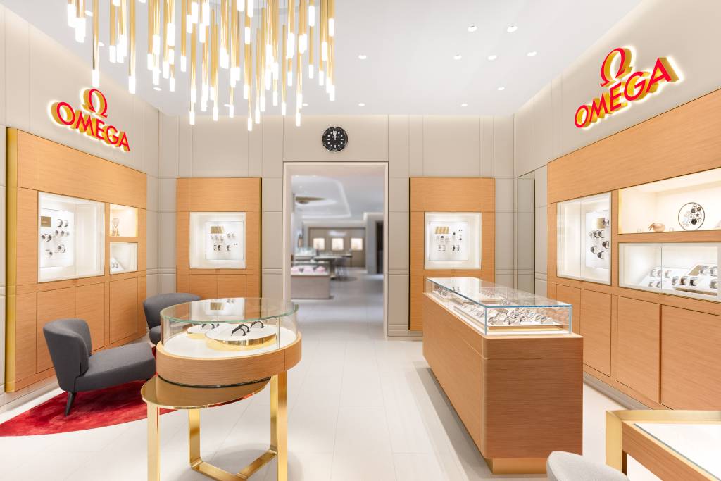 Omega watch store interior featuring displays and lighting (including a chandelier), showcasing luxury timepieces.