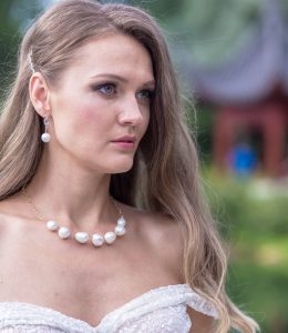 close up of necklace with large pearls and earrings