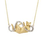 Gold necklace with a reclining cat pendant, its tail and a ribbon-like loop set with pavé diamonds.