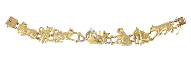 Gold necklace with a reclining cat pendant, its tail and a ribbon-like loop set with pavé diamonds.